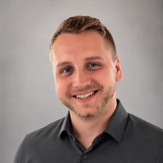 Tim Morgan, smiling, in a grey shirt